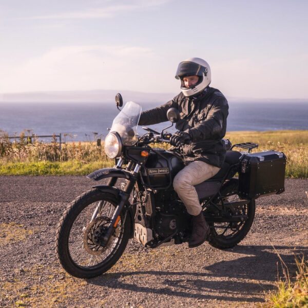 A motorcyclist on a Royal Enfield Himalayan, riding along The North Coast of Scotland.